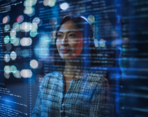 Professionnelle analysant des données et du code sur un écran numérique, illustrant les métiers de la data, de l’IA et de l’informatique.
